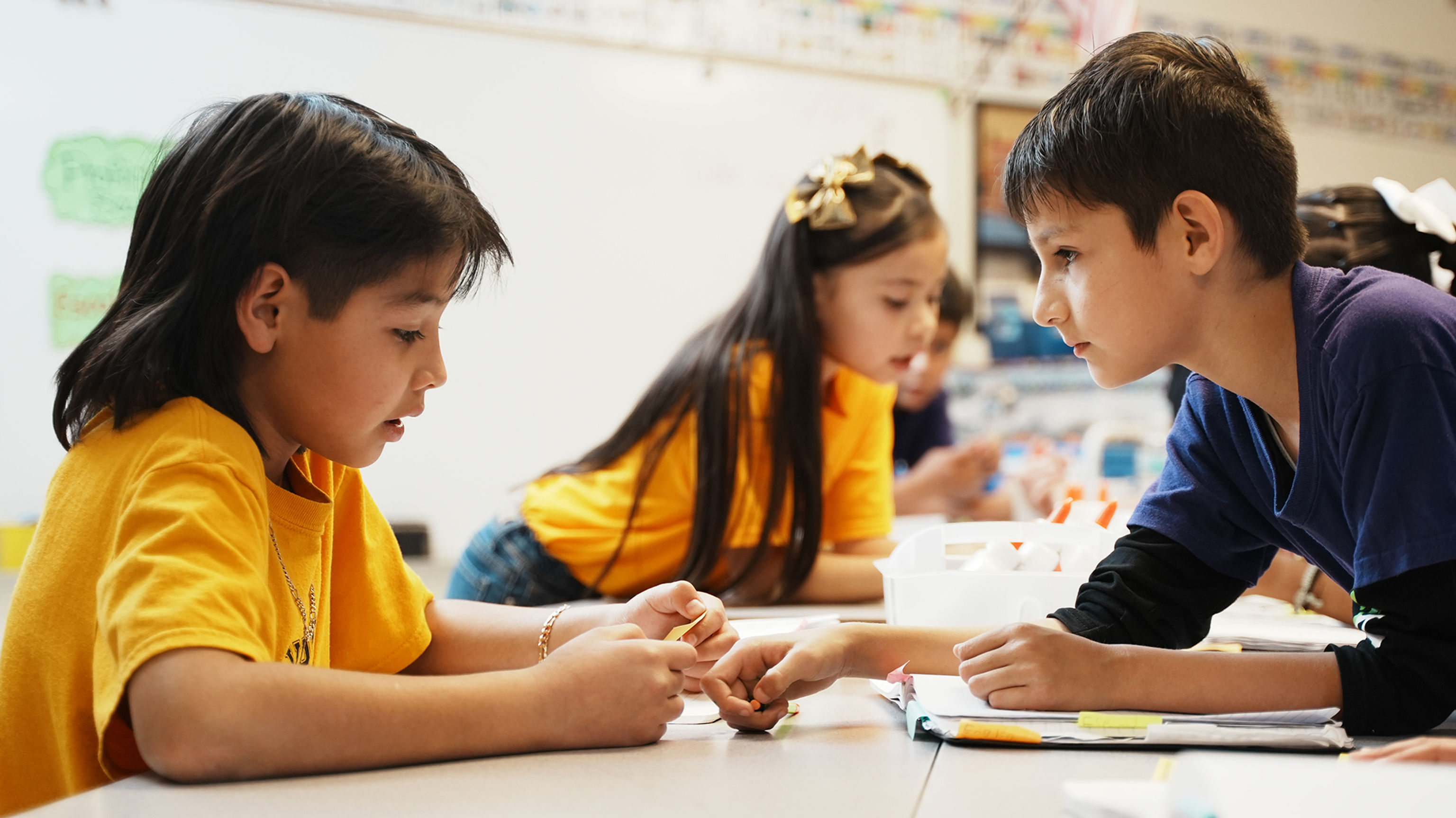 Two young students working at a table in class