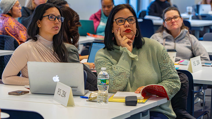 Two teachers listening to someone speaking off camera