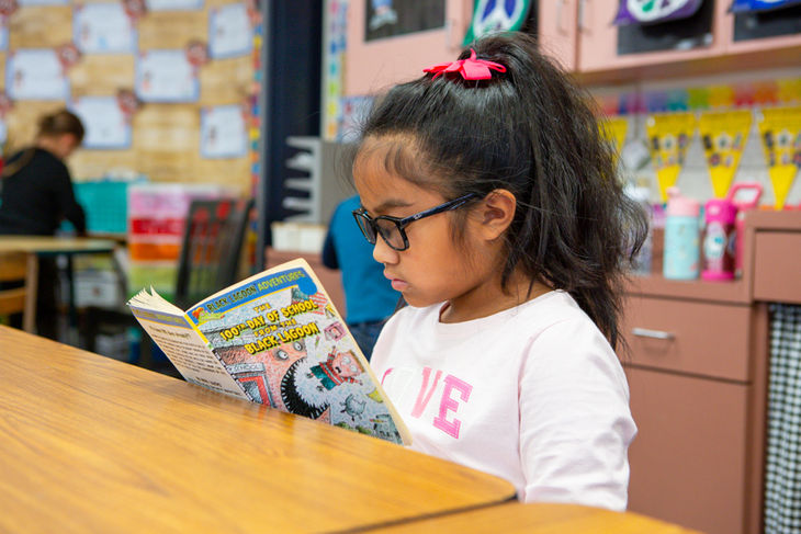 Girl reading a book in class