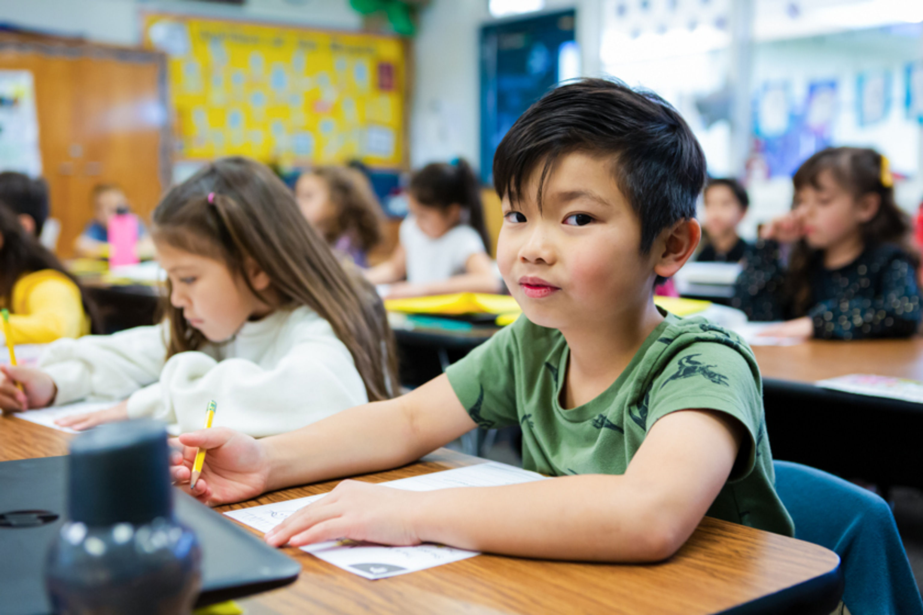 Student at his desk and looking into the camera