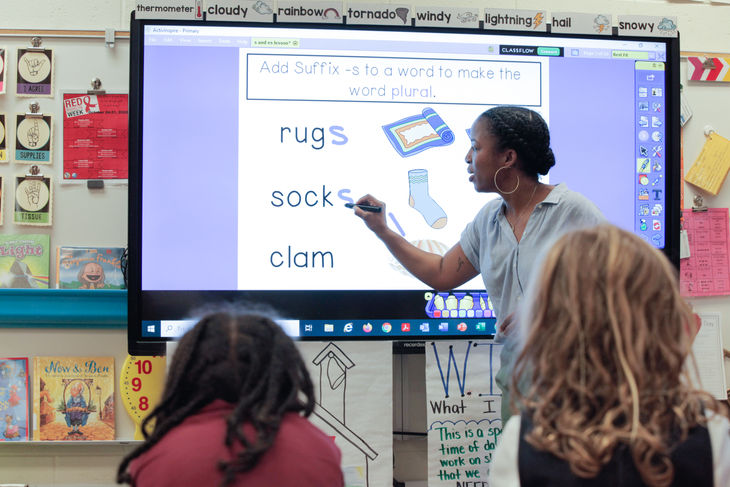 A black teacher giving whole group instruction on suffixes