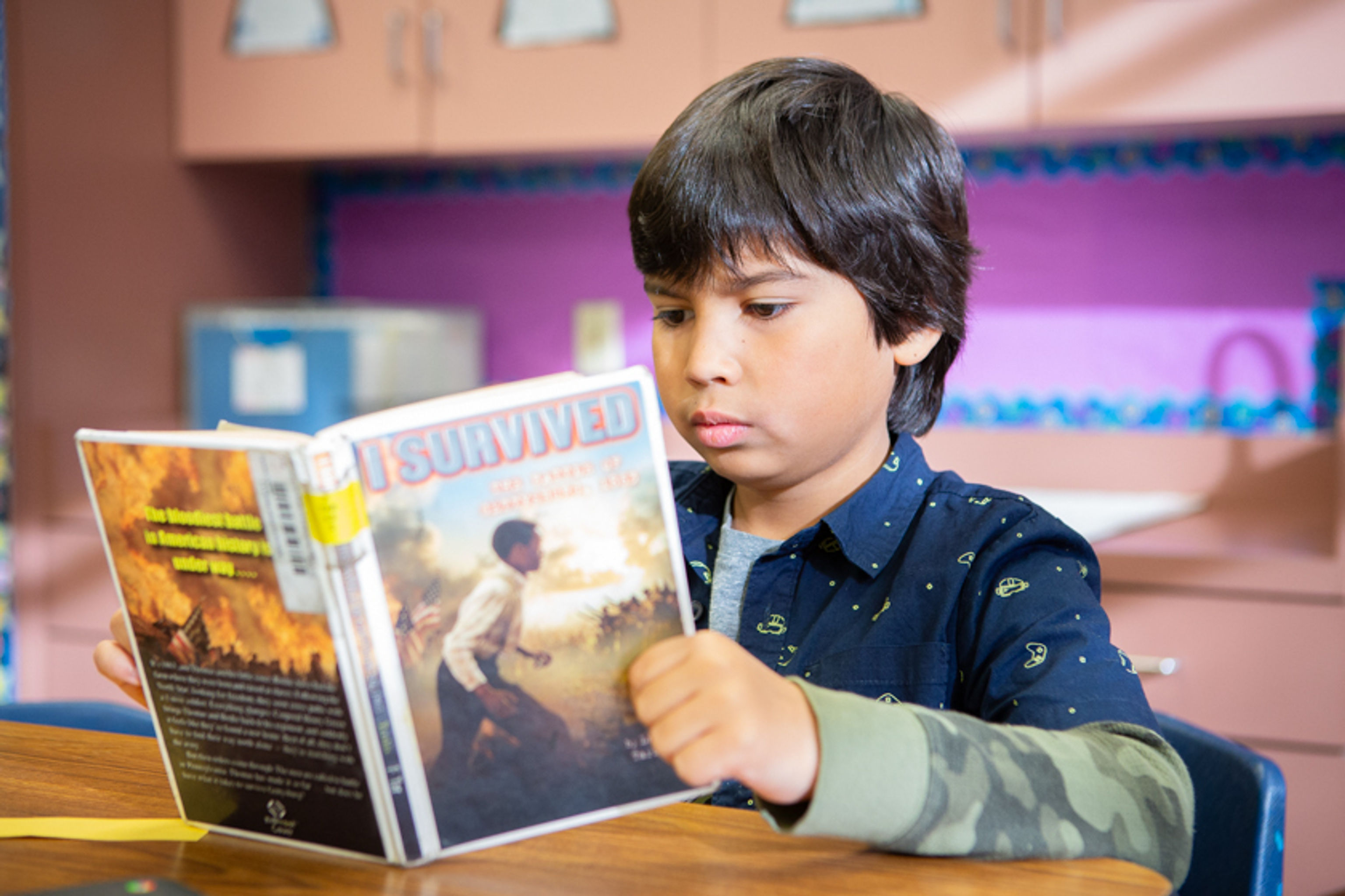 Second grade boy reading a book
