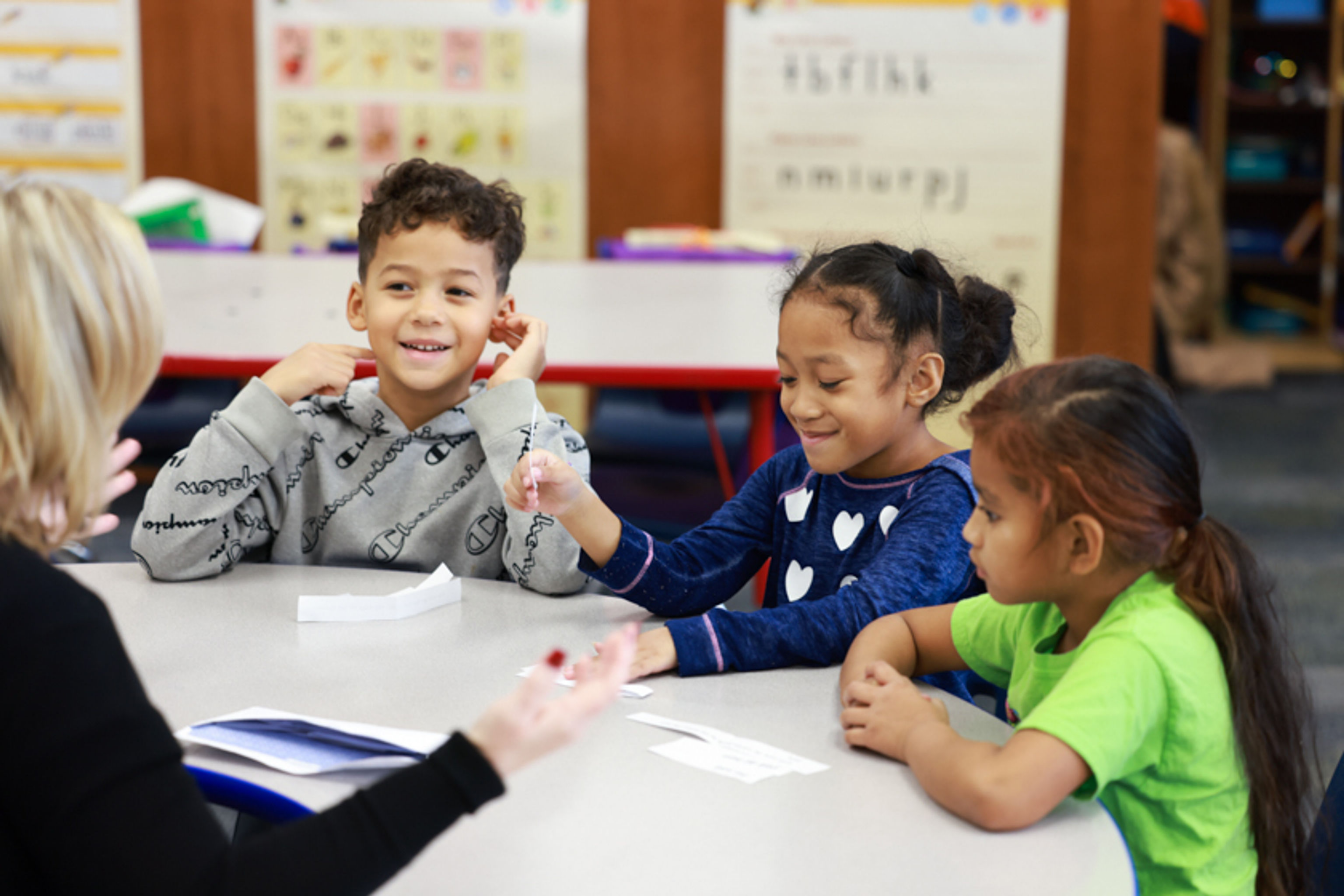 Teacher sitting at a classroom table with small group