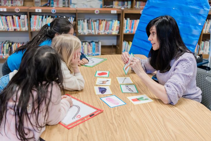 Teacher shows picture cards to students to develop phonological skills