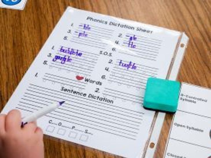Student using a dry erase marker on a worksheet in a clear sleeve