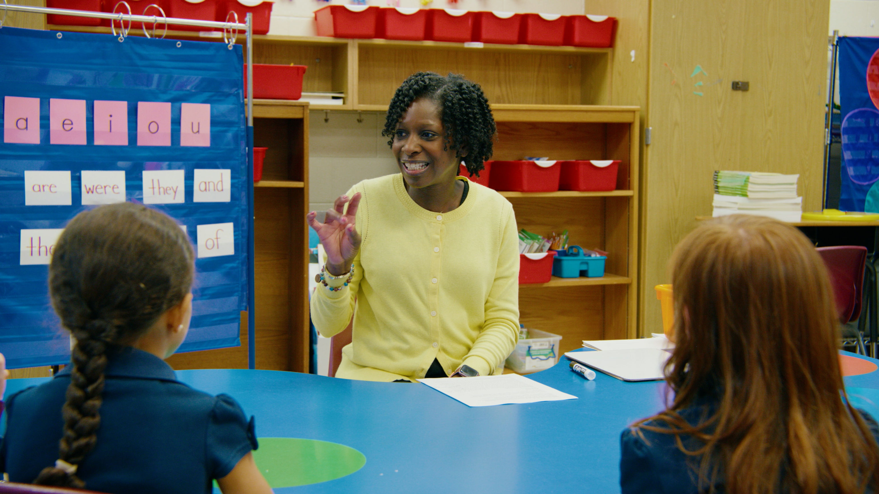 Teacher counting out phonemes with her fingers with students