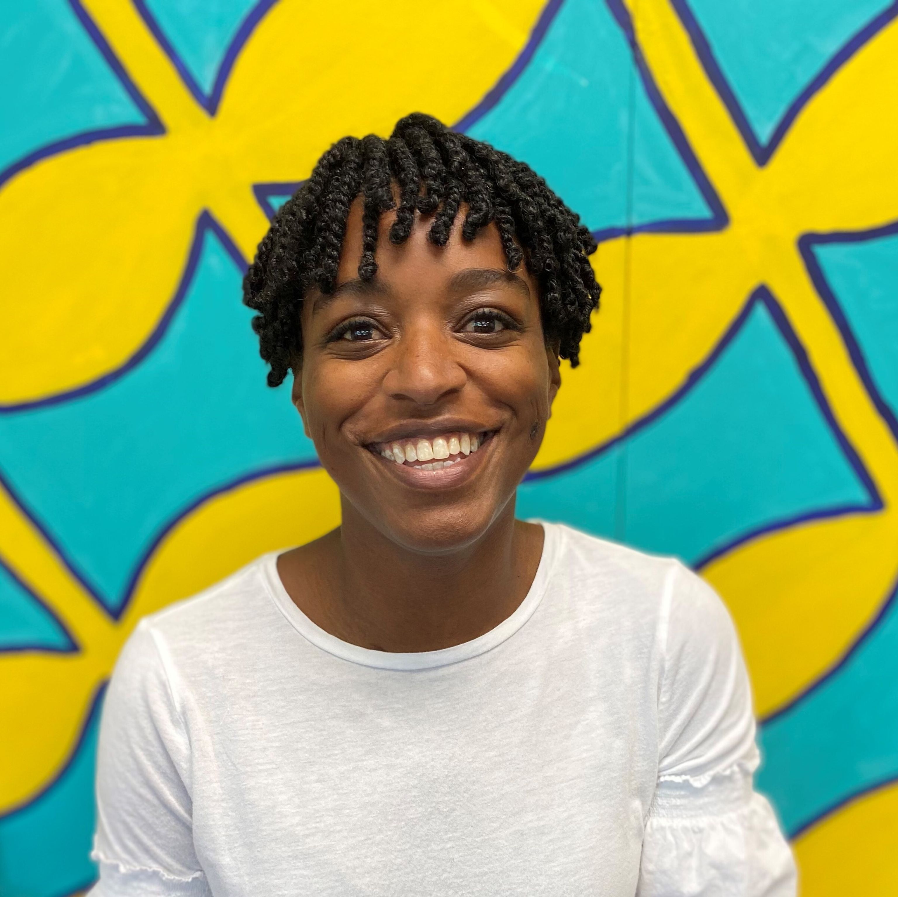 Bettina Hilliard smiling in front of brightly colored background