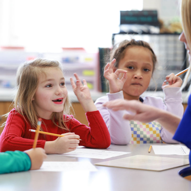 Young girl segmenting and blending phonemes using her fingers.