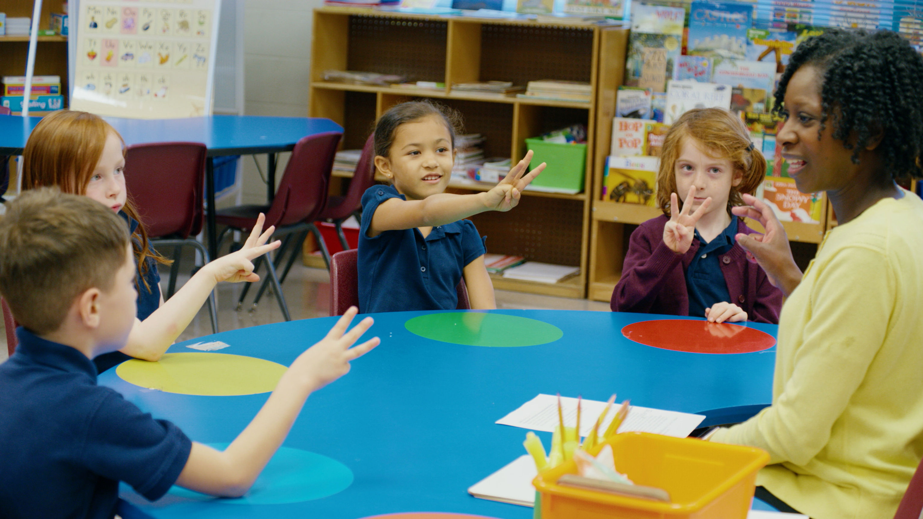 Kids and teacher using fingers to do segmenting and blending of phonemes