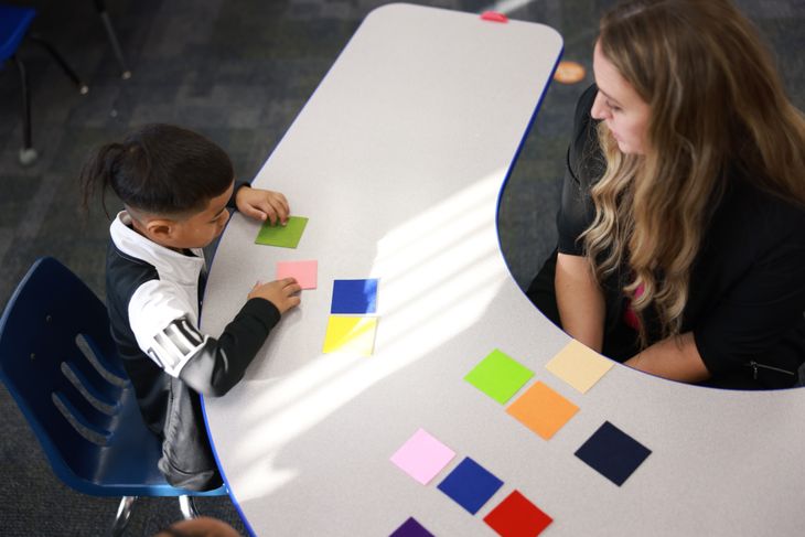 Teacher working with a student using colored felt squares