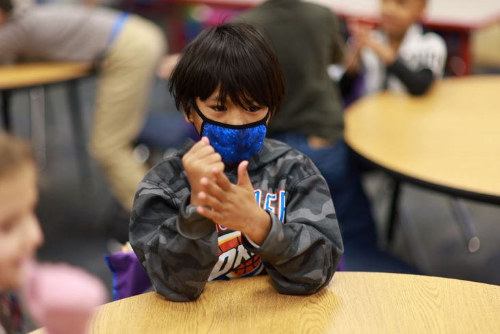 First grader making fist to learn how to segment syllables with stomp and say.