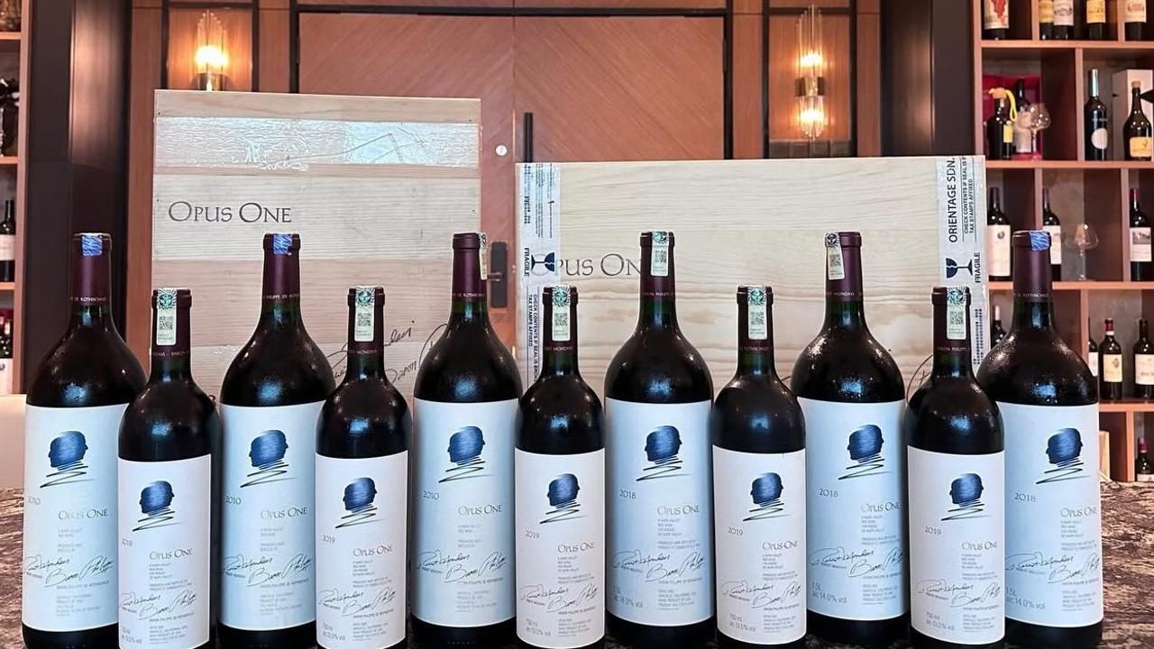 多支 Opus One 作品一號與木箱，白色正標可見藍色雙人輪廓及不同年份
