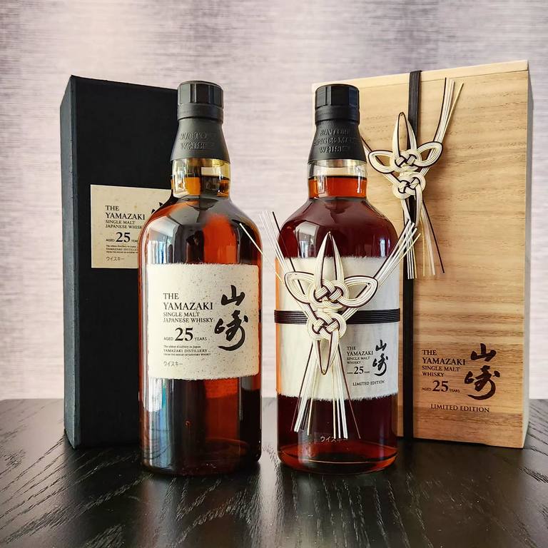 山崎25年酒瓶與黑色外盒,旁為Limited Edition酒瓶及木盒