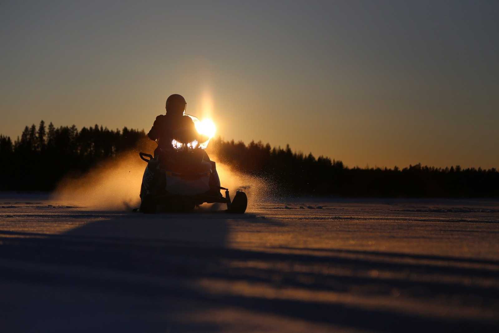 Snowmobiling in Mont Tremblant - snowmobiler at sunset