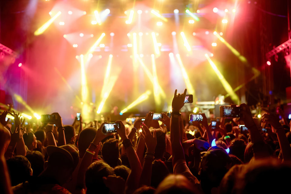 Crowd happily dancing and singing on a concert