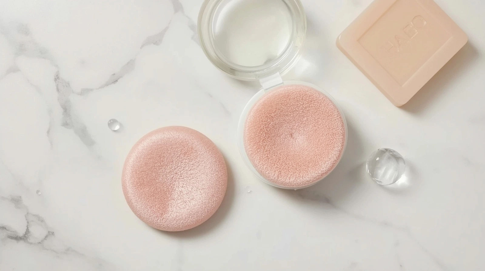 Puff makeup lembut di samping sabun sebagai ilustrasi cara membersihkan puff cushion dan bedak tabur secara rutin