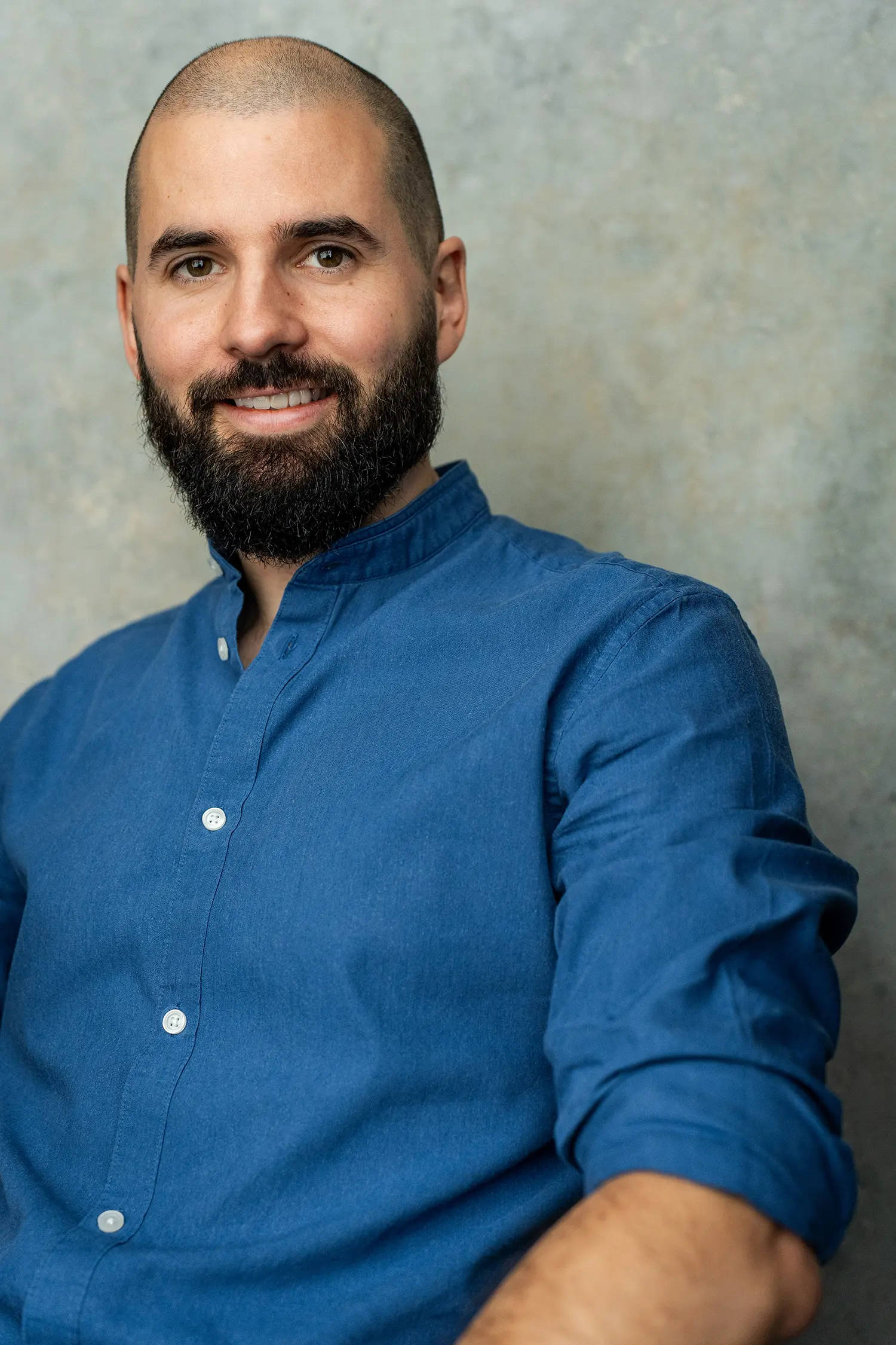 Photo of James Morris, Psychotherapist in Poole & London, wearing a blue shirt and smiling.