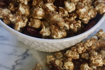 Caramel corn in white bowl on marble counter