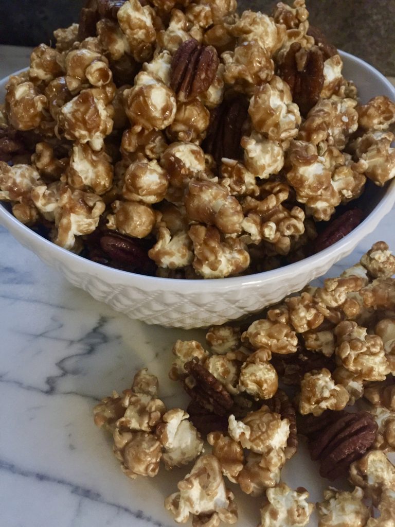 Caramel corn in white bowl on marble counter