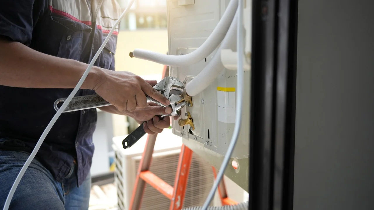 Close-up of hands adjusting a boiler system with precise instrumentation, showing maintenance work.