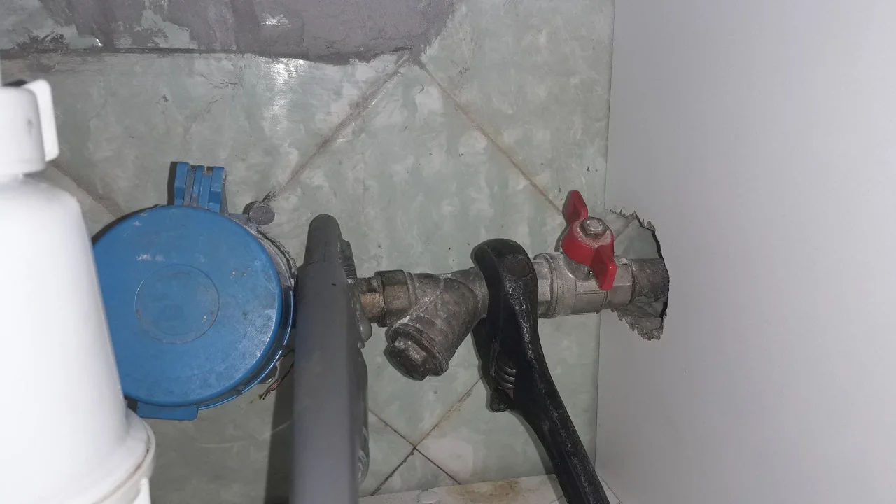 From above of crop anonymous person in yellow rubber protective glove using sponge and detergent for washing white sink in bathroom