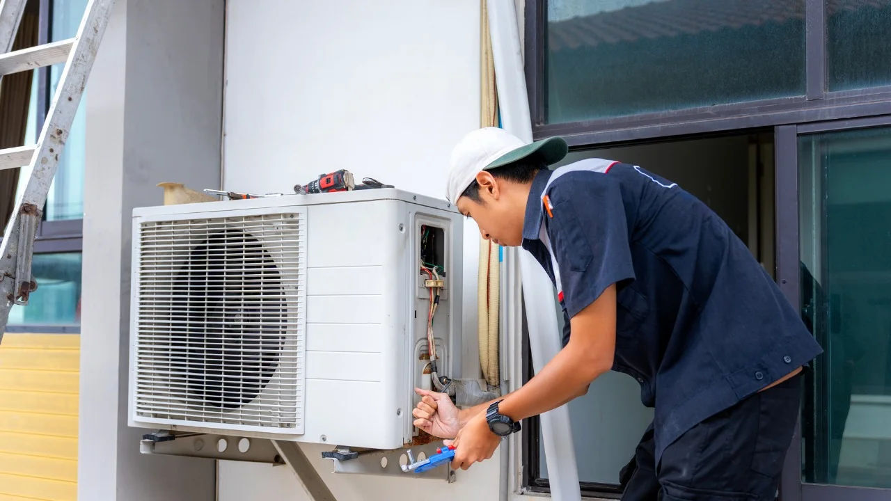 A technician inspects an outdoor HVAC unit for maintenance.