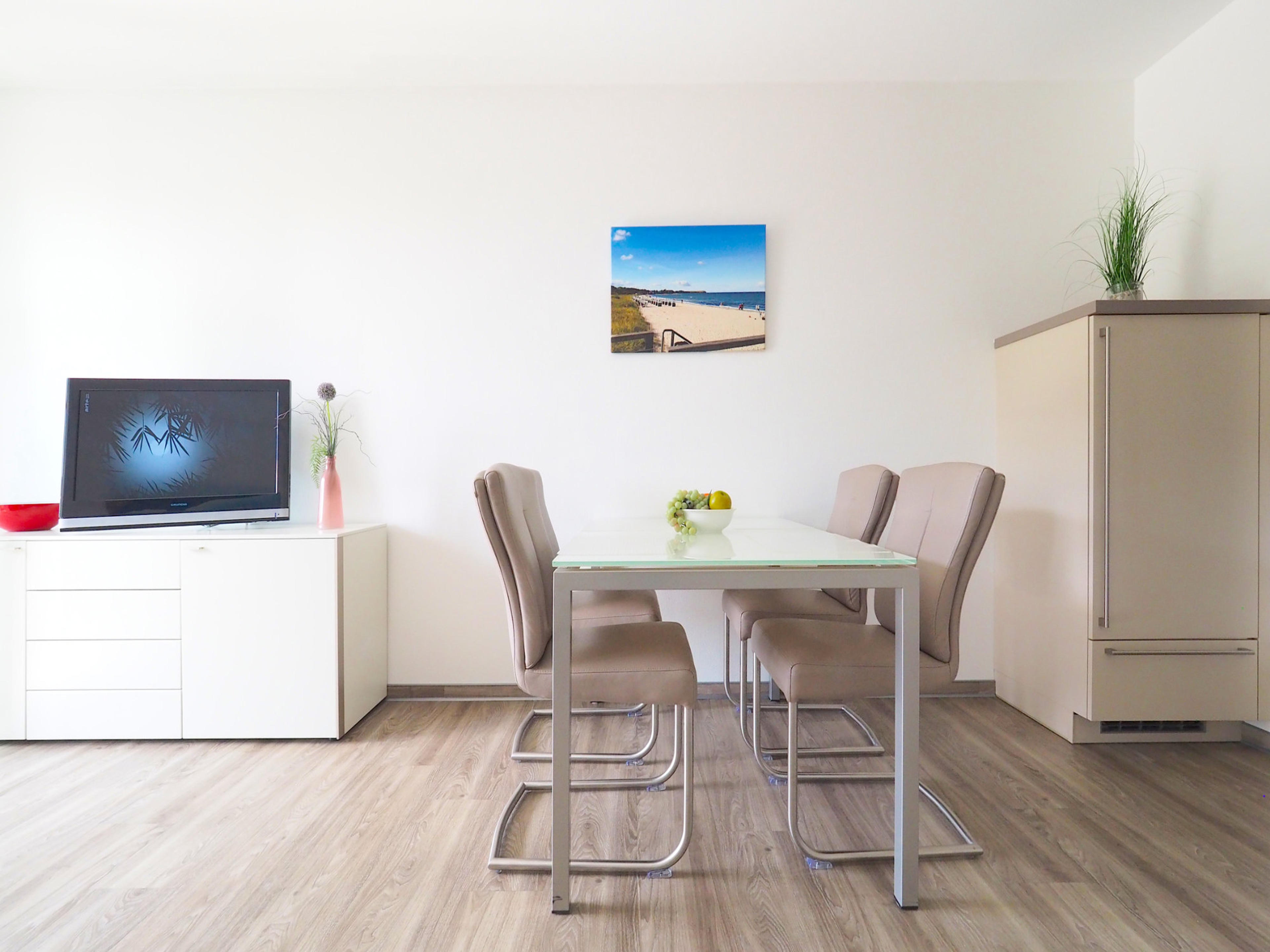 Esstisch mit vier Stühlen, Sideboard mit Flatscreen-TV