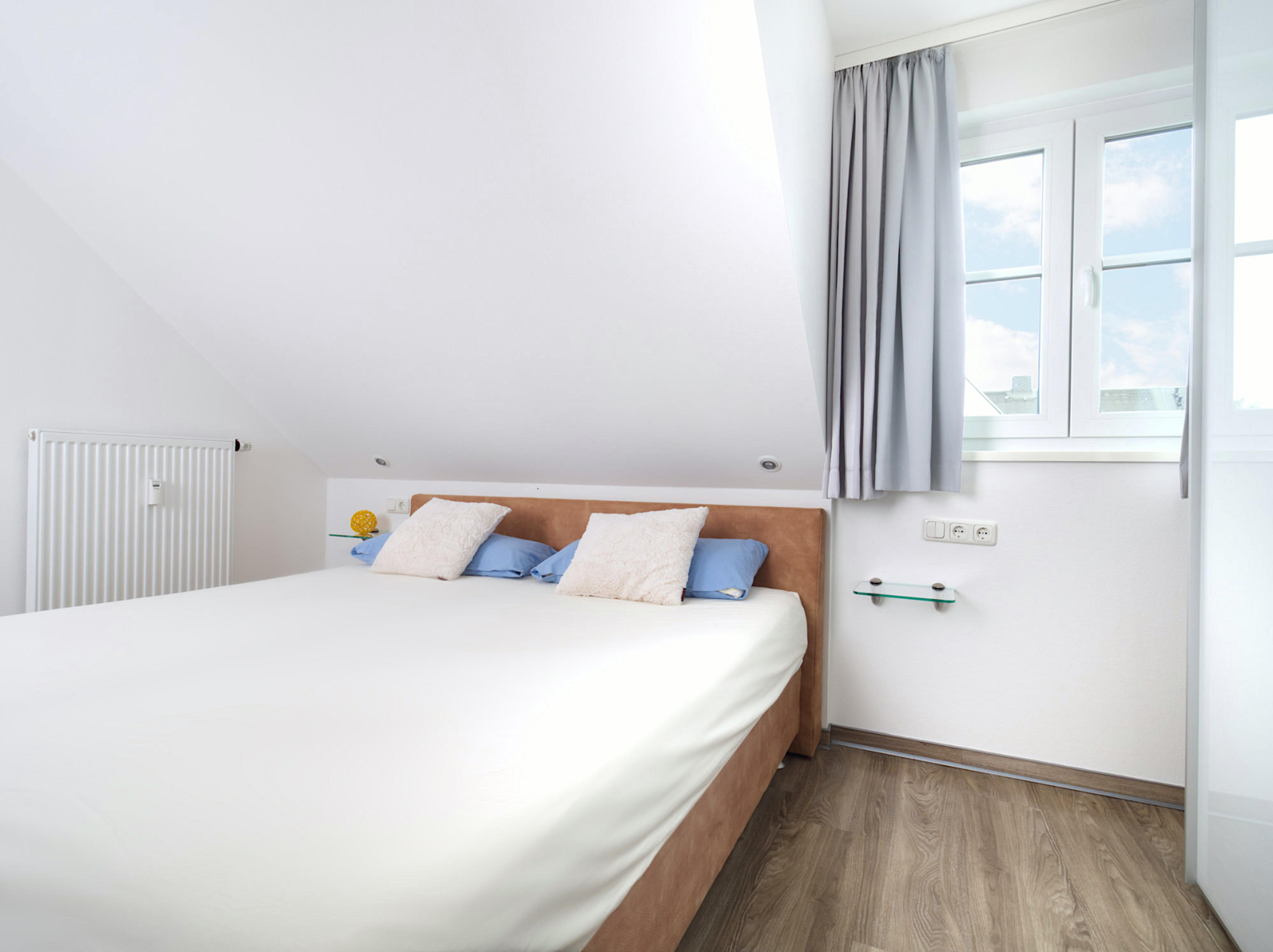 Meeresbrise, Ferienwohnung 08, zweites Schlafzimmer mit großem Doppelbett und Blick zum Fenster