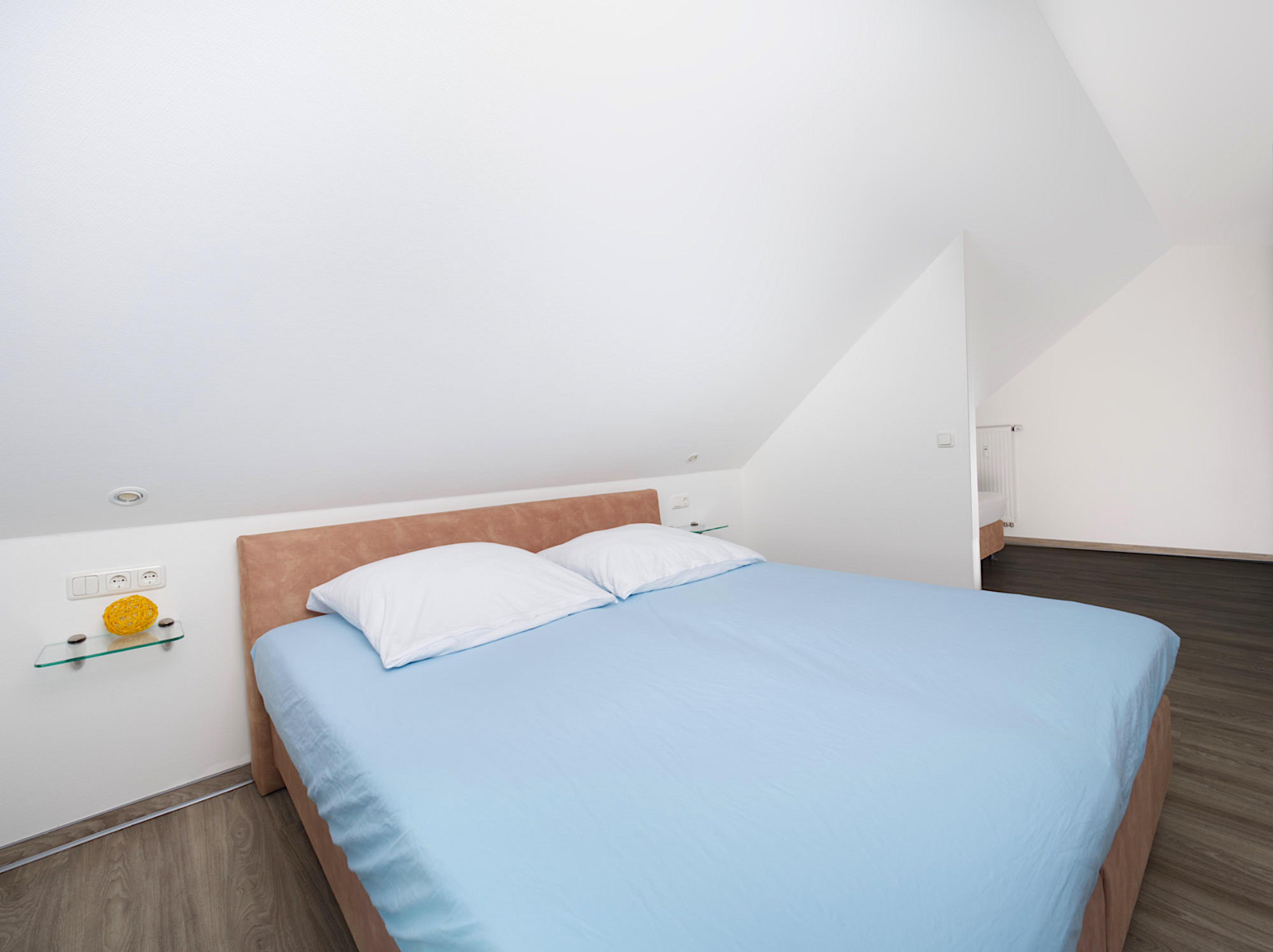 Meeresbrise, Ferienwohnung 09, Schlafzimmer mit großem Doppelbett und Blick zum hinteren, leicht abgetrennten Bereich