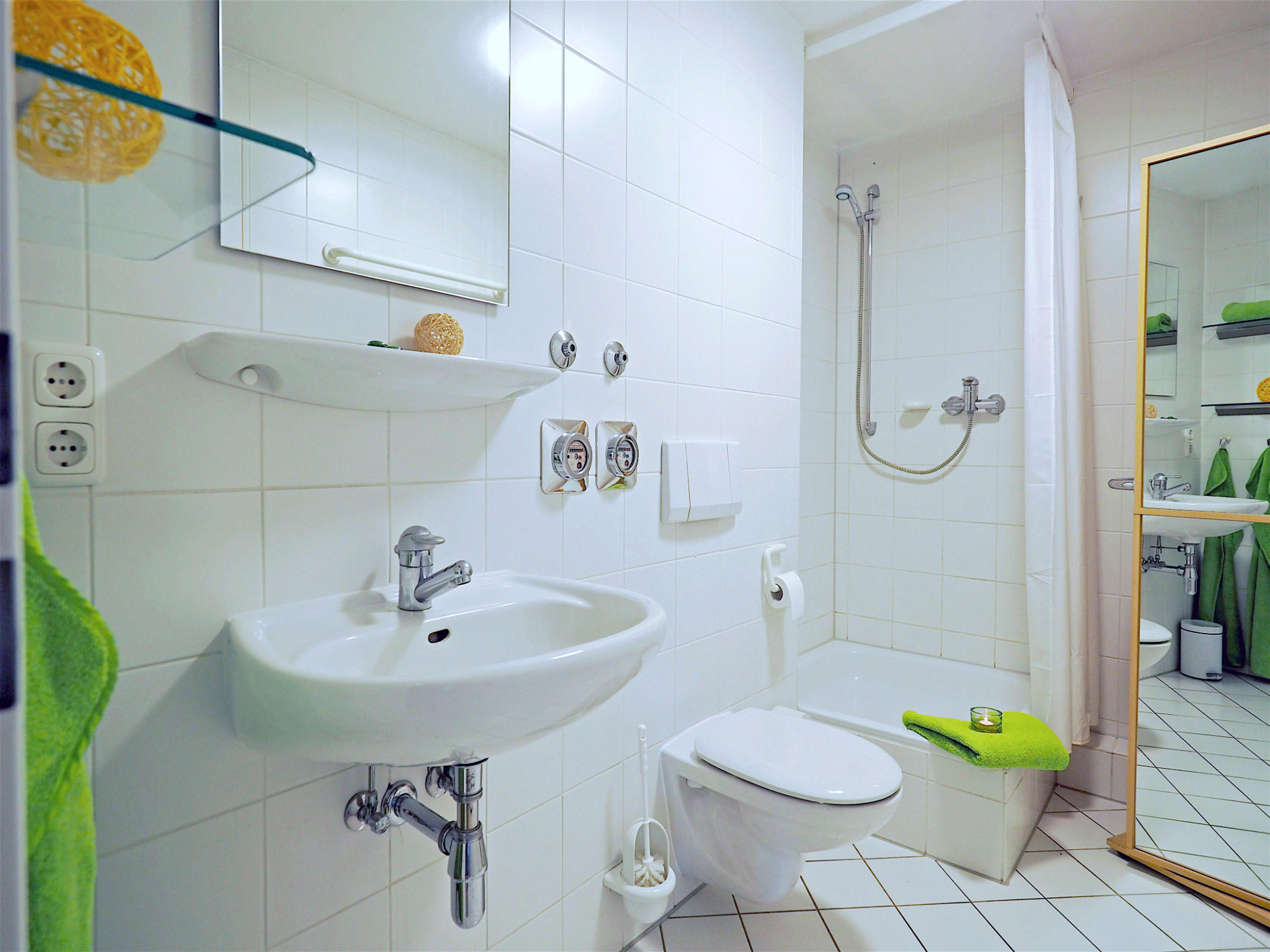 Duschbad mit Waschbecken, WC, Dusche und Hochschrank mit Spiegelfront