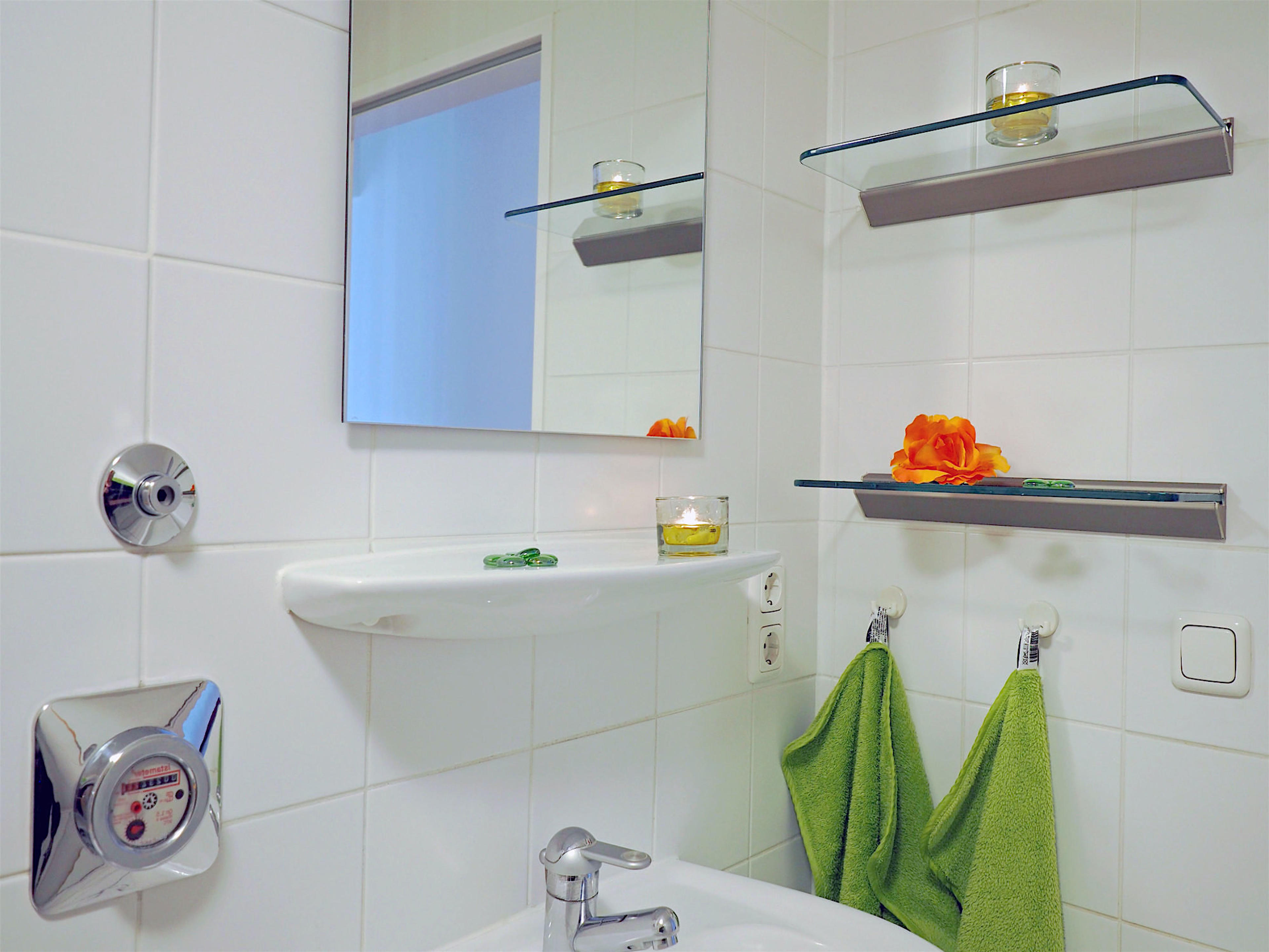 Duschbad mit Waschbecken und Spiegel sowie Glaskonsolen