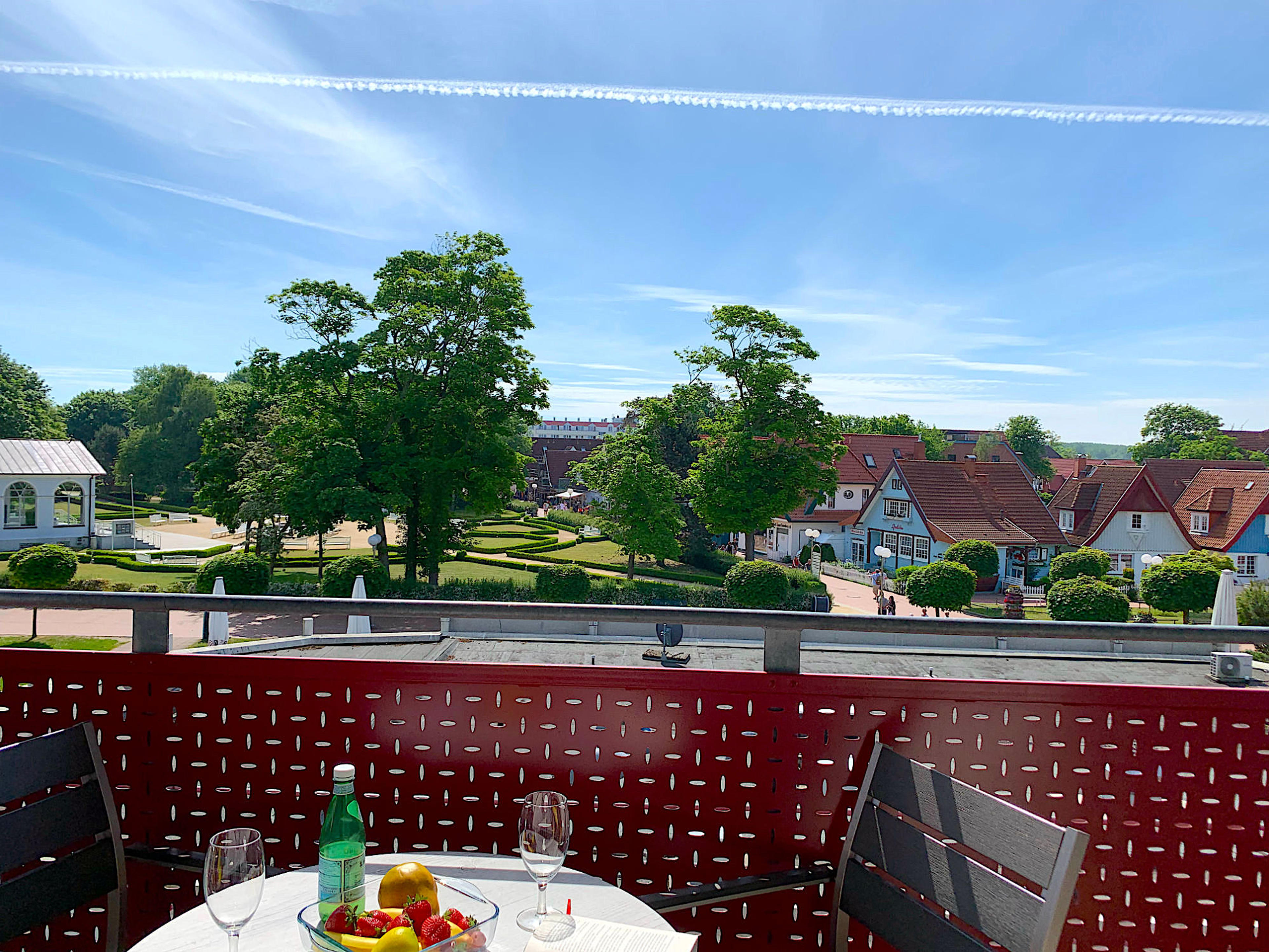 Balkon mit Tisch und Stühlen und Blick in den Kurpark