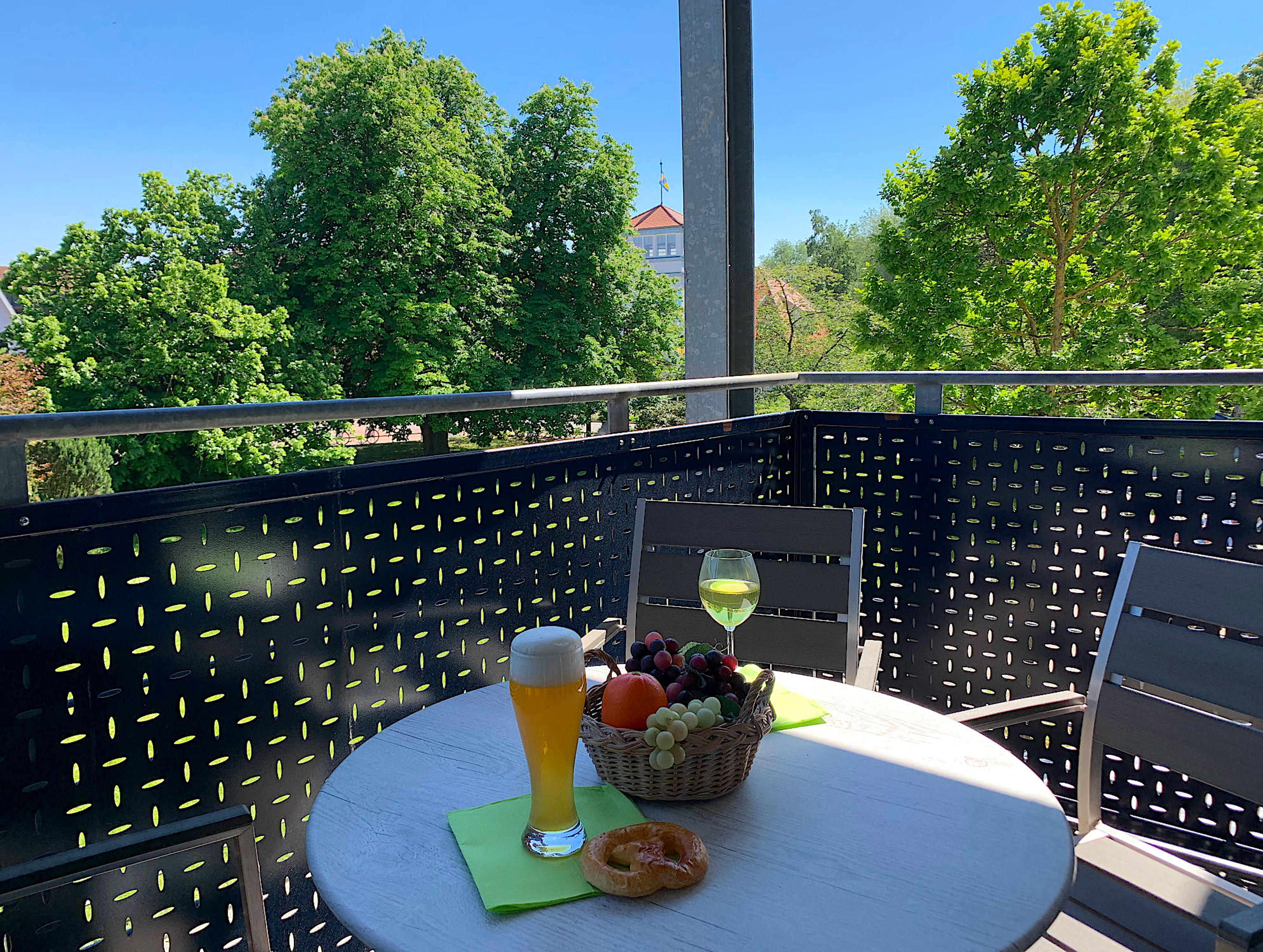 Balkon mit Tisch und Stühlen, Blick ins Grüne und zum Kurhaus