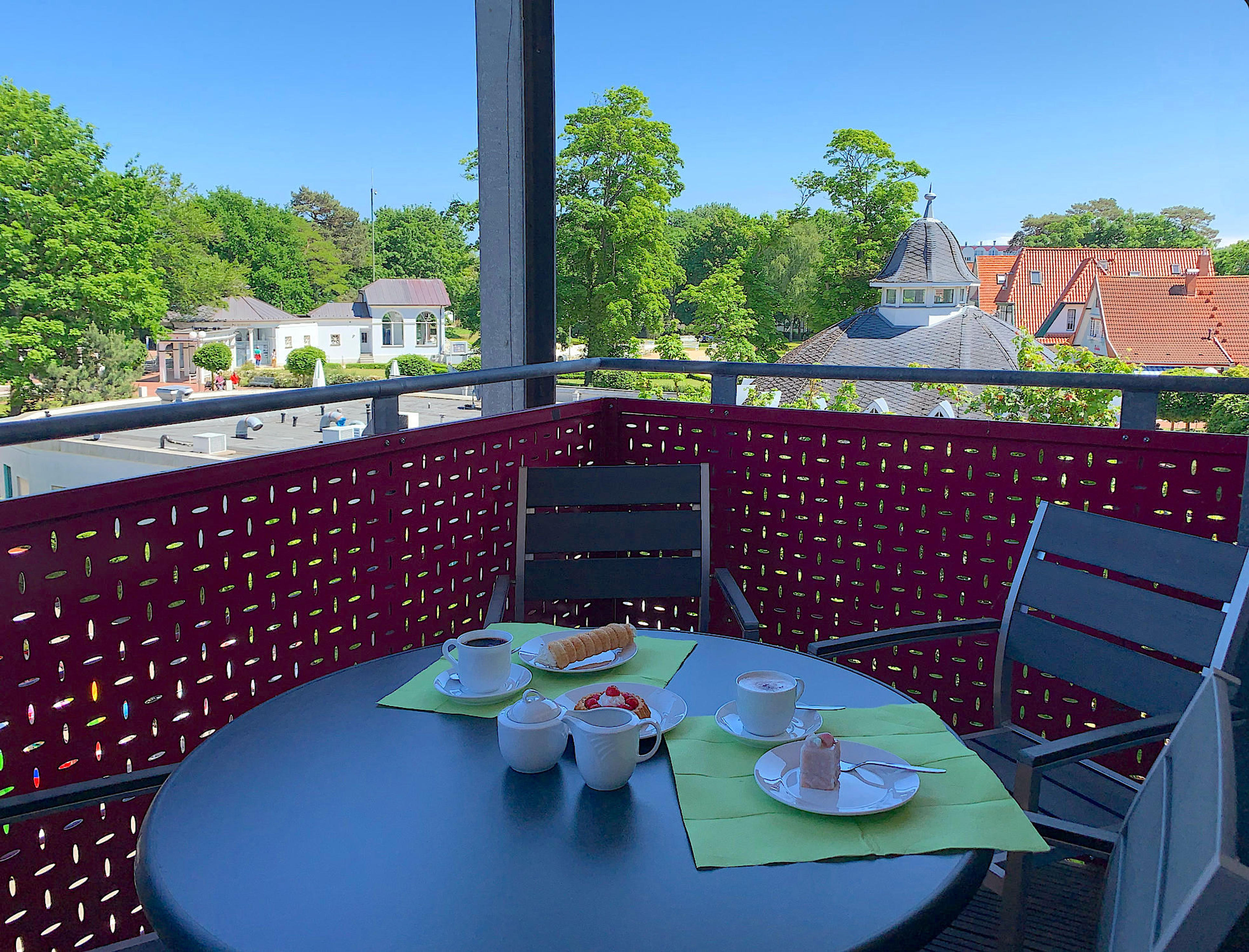 Balkon mit Tisch und Stühlen, Blick in den Kurpark