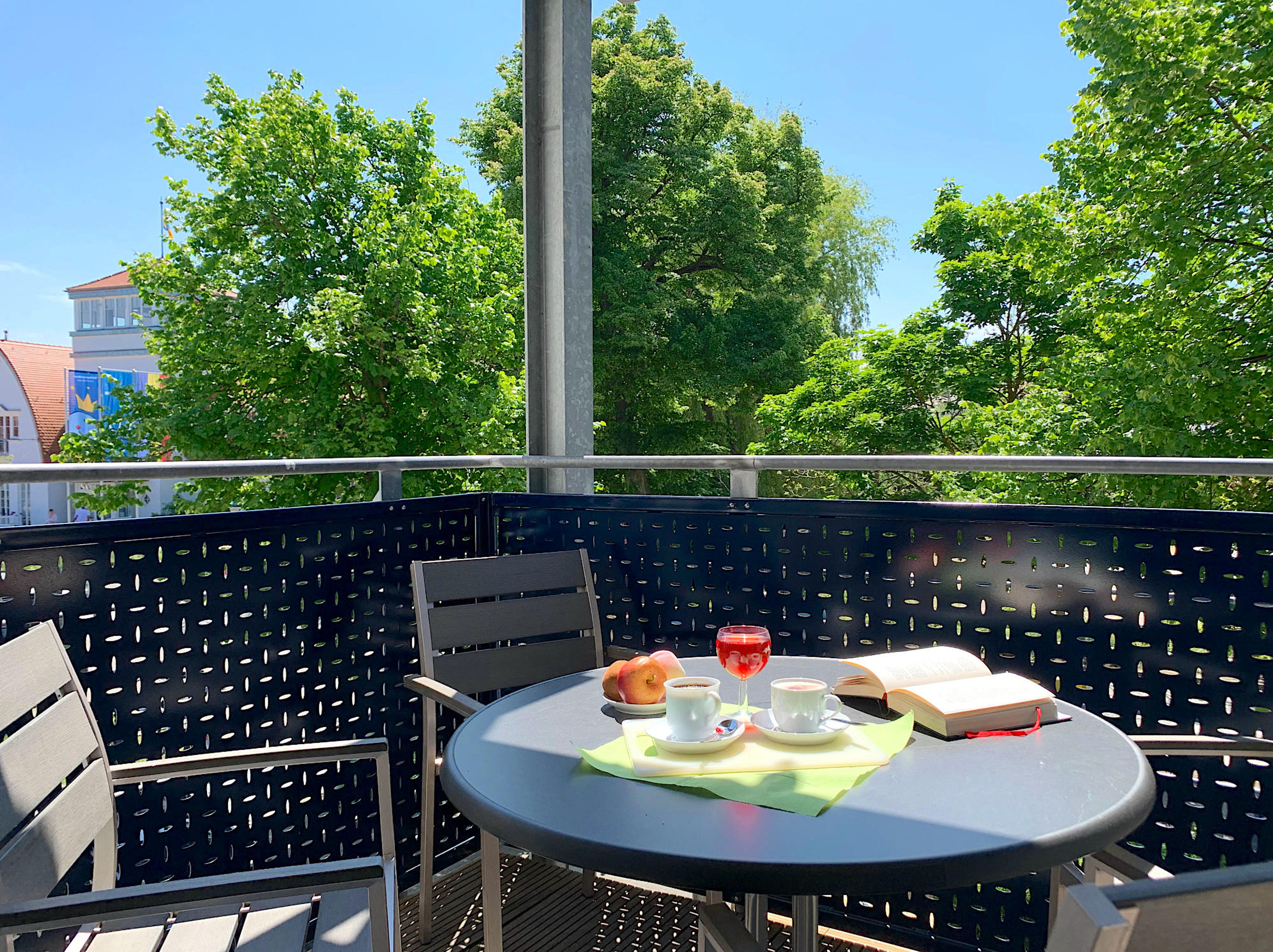 Balkon mit Tisch und Stühlen und Blick zum Kurhaus