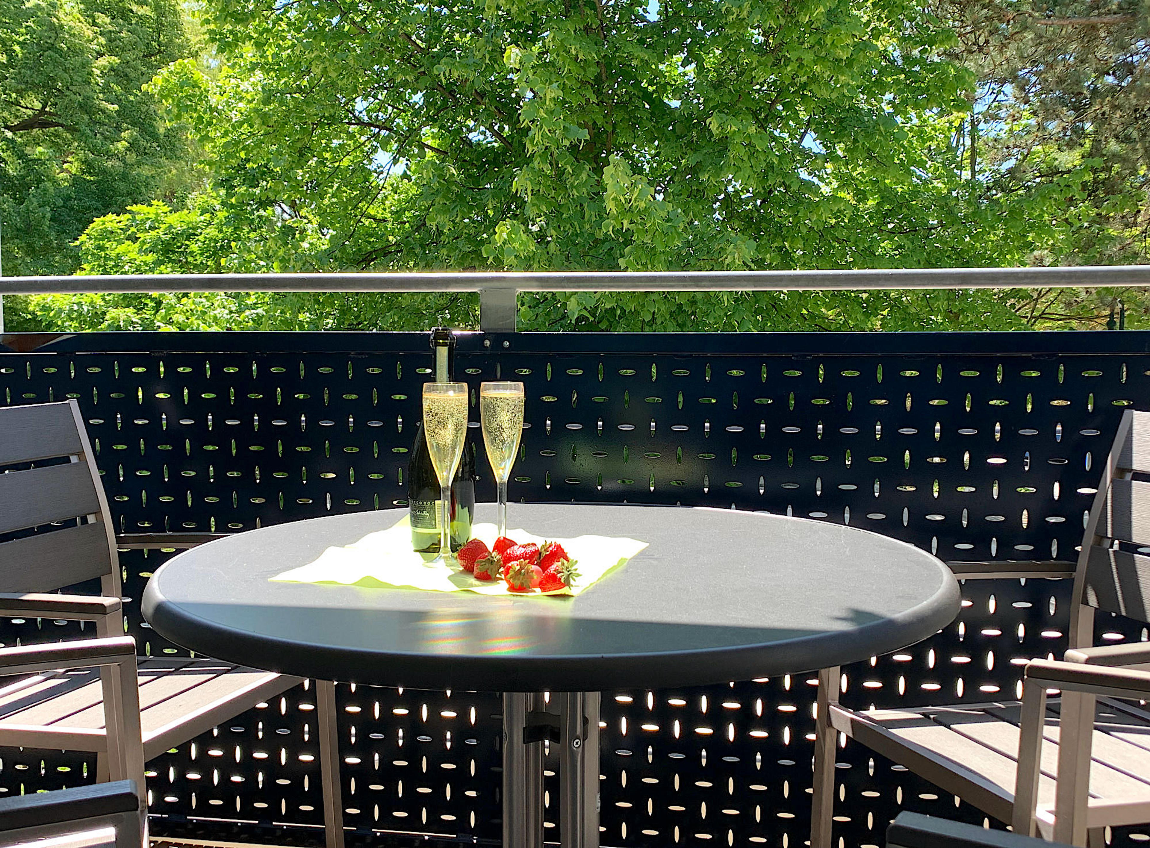 Balkon mit Tisch und Stühlen und Blick in`s Grüne