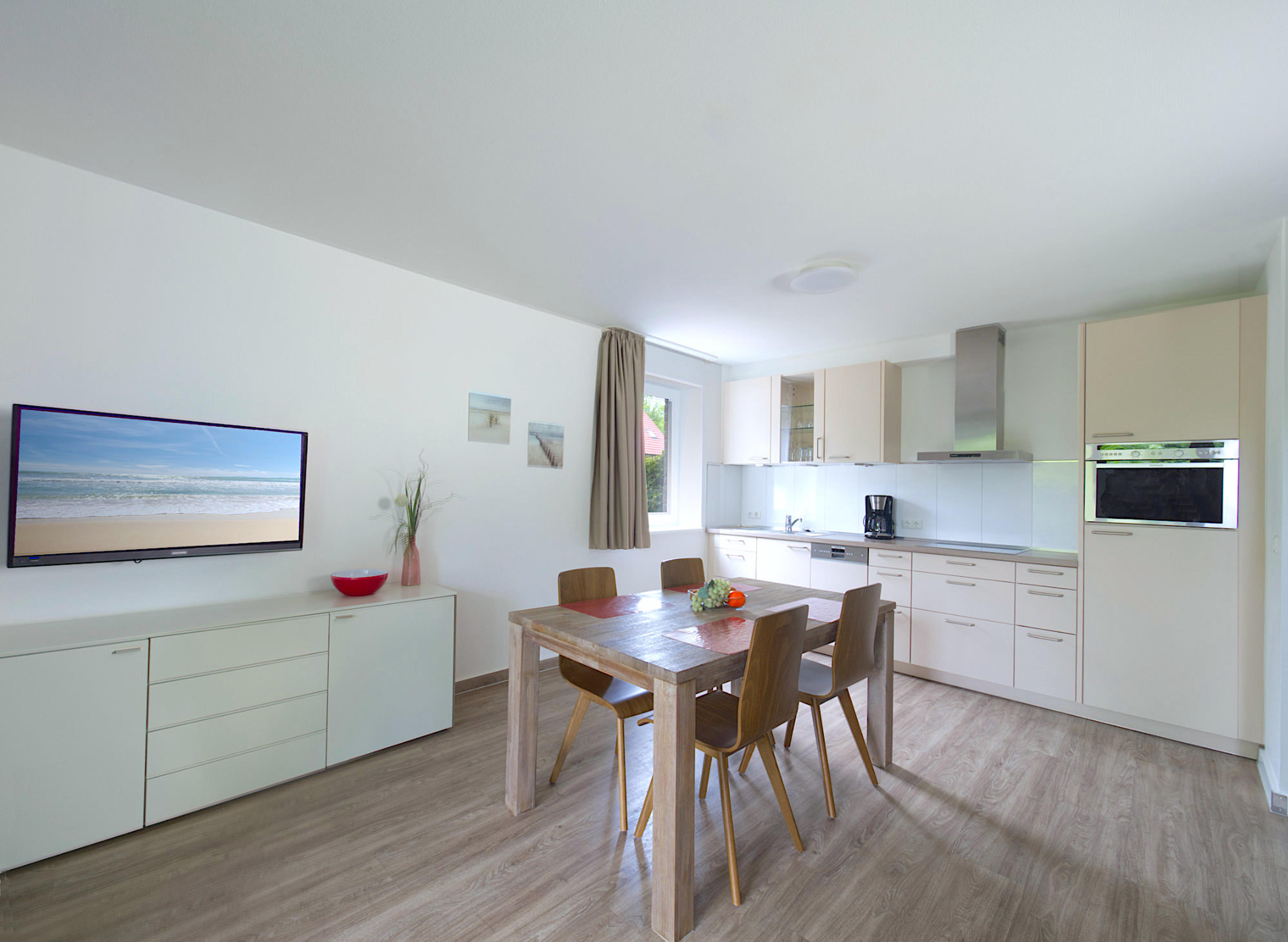 Weidenblick, Ferienwohnung 04, Essbereich mit Holztisch und 4 Stühlen, rechts daneben ist die Einbauküche, links  Sideboard