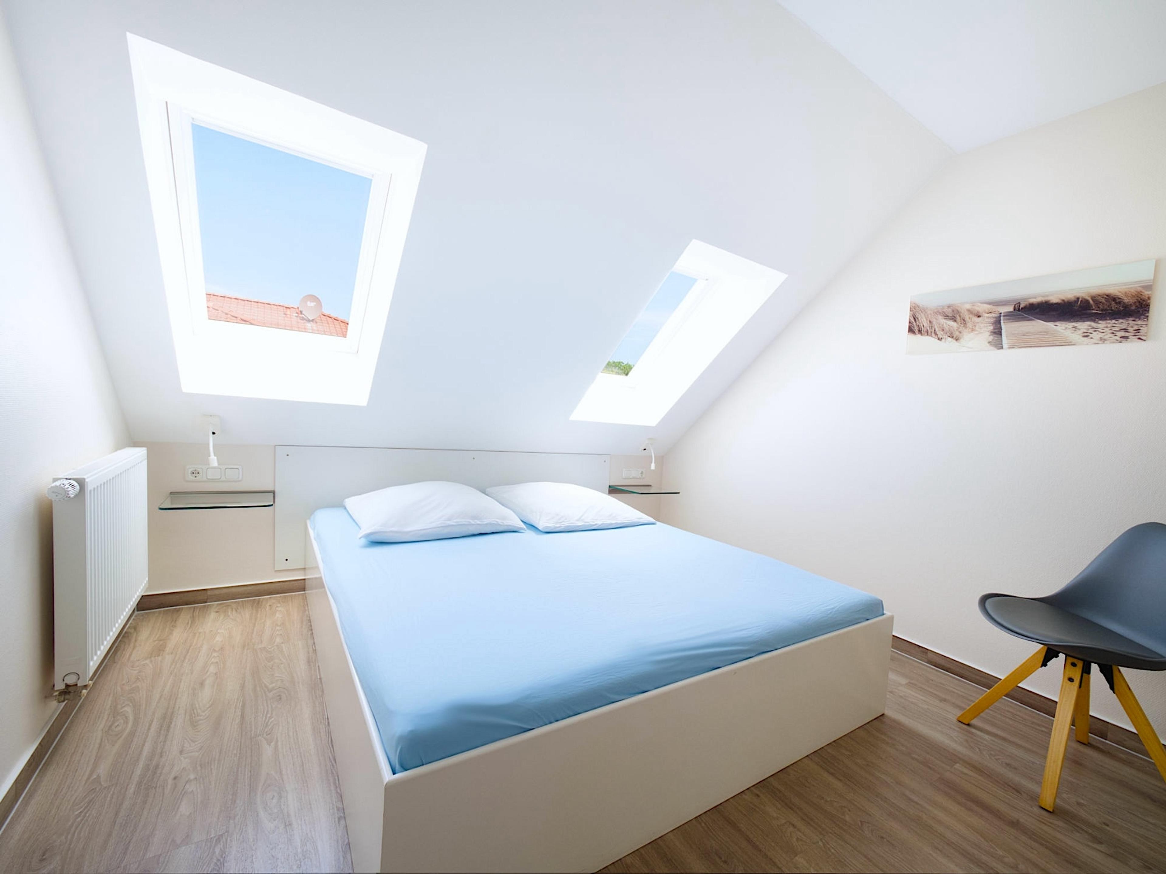 Weidenblick, Ferienwohnung 09, Schlafzimmer mit großem Doppelbett und Nachttischkonsolen aus Glas