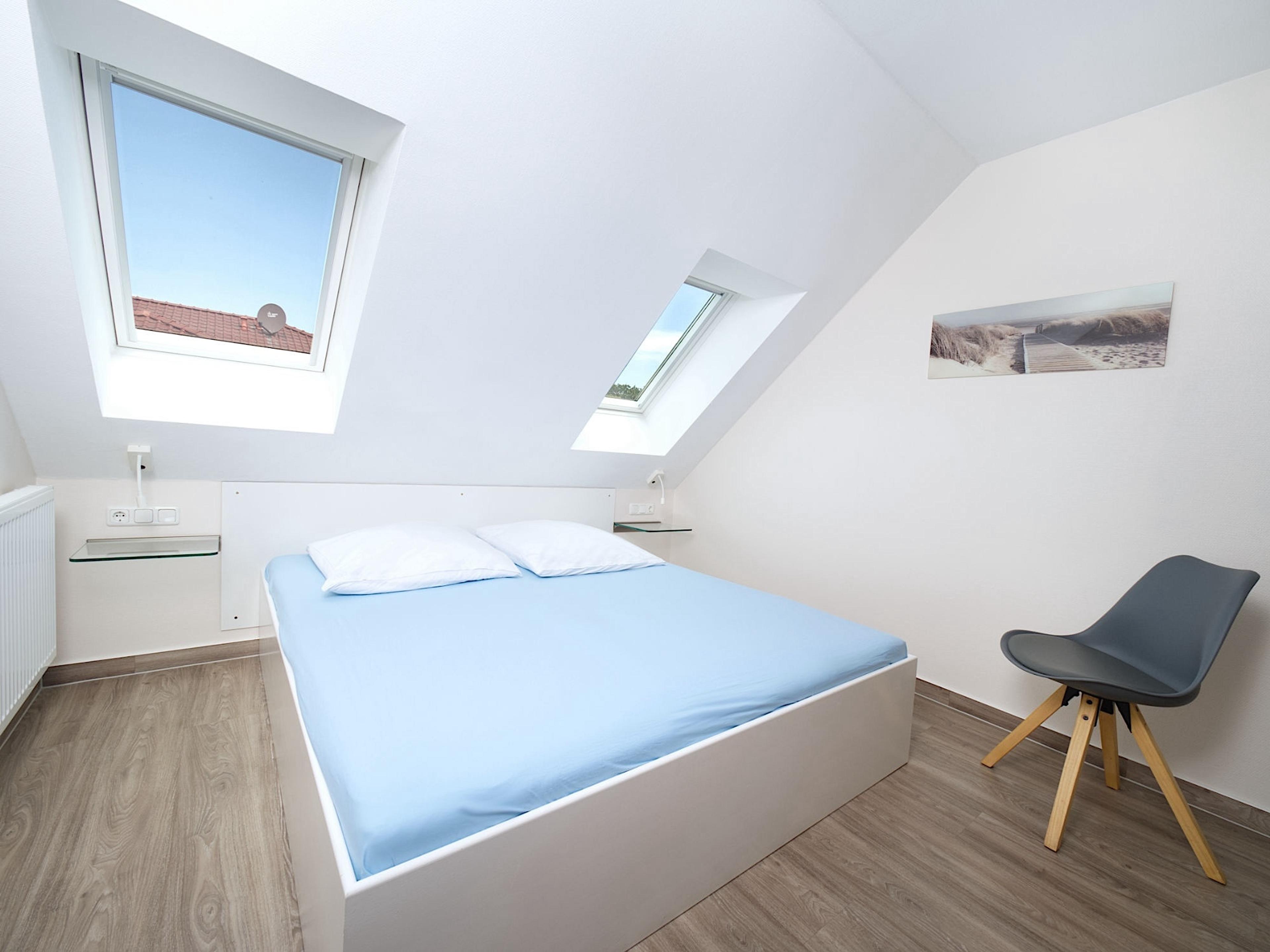 Weidenblick, Ferienwohnung 09, Schlafzimmer mit großem Doppelbett und Nachttischkonsolen aus Glas