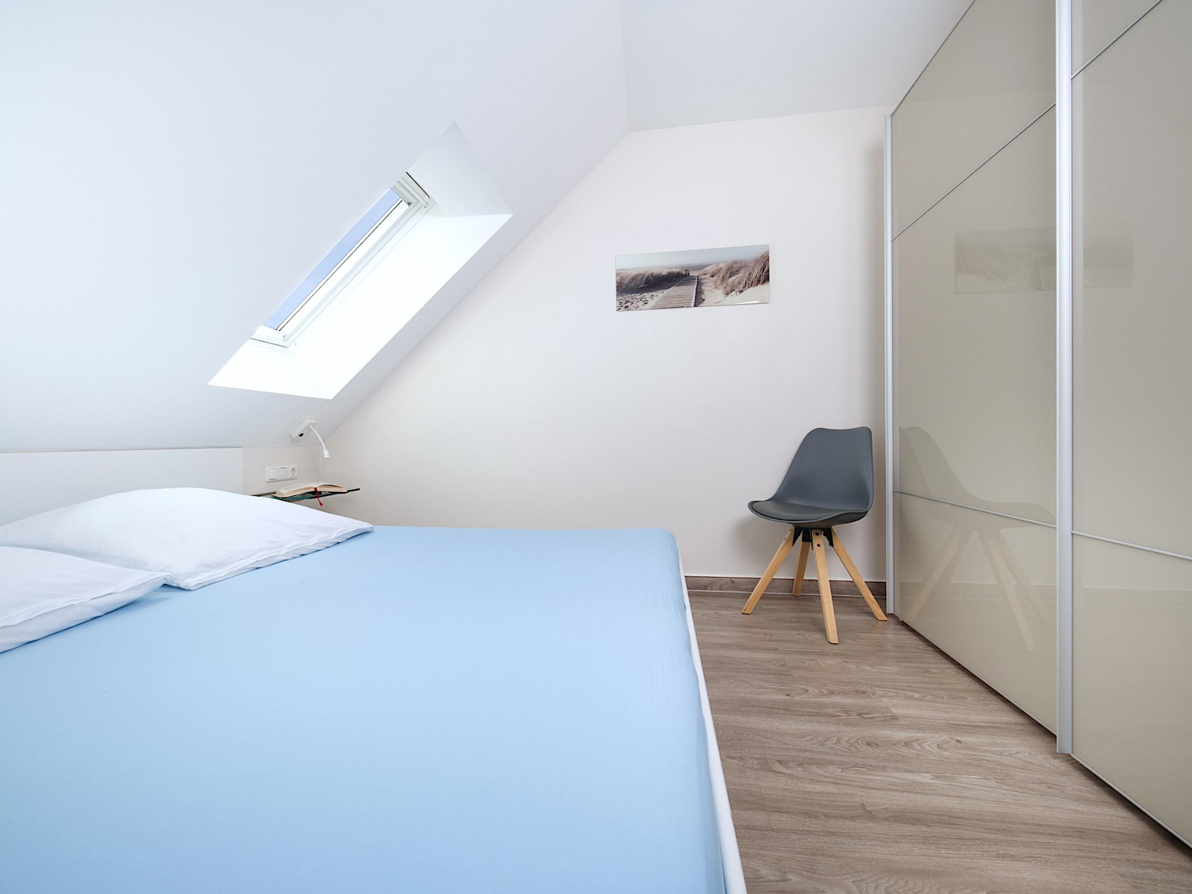 Weidenblick, Ferienwohnung 11, Schlafzimmer mit großem Doppelbett, rechts ein großer Kleiderschrank mit Schiebetüren