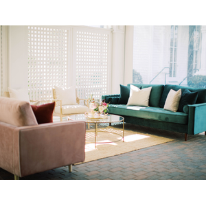 Pink couch, green couch, two linen chairs, gold coffee table, and jute rug 
