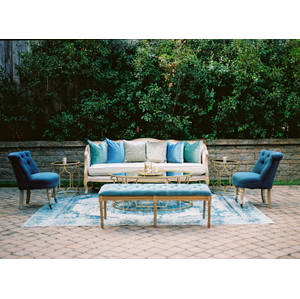 linen sofa with blue chairs and bench in front of stone wall at The Cookery Durham
