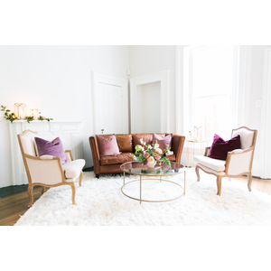 Leather sofa with two linen chairs on fluffy white carpet 