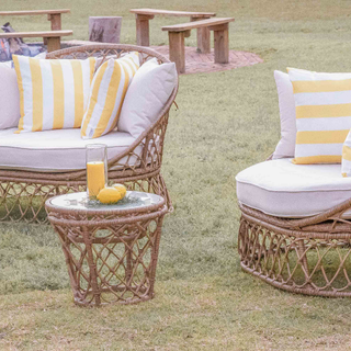 Boho seating lounge with yellow striped pillows and lemons on table by fire at The Space at Feather Oaks wedding.