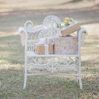 white wicker chair with wrapped presents outside