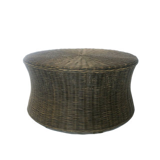 Wicker coffee table surrounded by rattan wicker chairs with draping sheers at The Space at Feather Oaks.