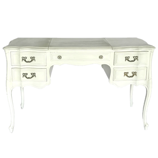 Vintage ivory beige rectangular dresser accent table with sweets in trays on top of it in a room with black printed floors. Two other table dressers sit on each side of the table, one is pink and one is blue with sweets on it as well. Floral decor is in t