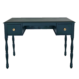 Vintage indigo blue rectangular dresser accent table on grass wiht a lake behind it. A bride and groom warmly embrace with the groom sitting on top of the table and the bride touching his face. 