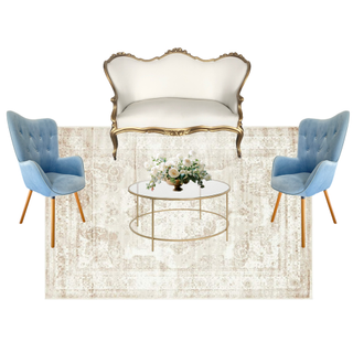 lounge set with Vintage gold and ivory beige sofa with a modern gold and glass coffee table with a vintage tufted blue chair on each side of the coffee table over an ivory beige rug. 