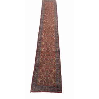 vintage boho red rectangular runner rug down a grass aisle with chairs in rows on either side where people sit facing an altar with a geommetric arbor with a couple standing in front holding hands. 